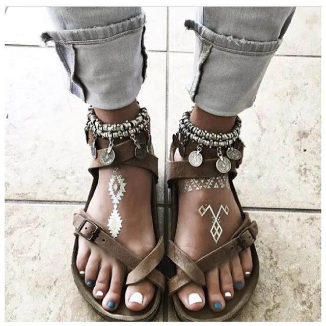 Samara Weaving showing decorated flat sandals beneath rolled-up jeans.