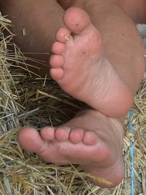 Amanda Seyfried with bare soles resting against straw in close view.