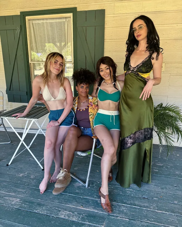 Kiernan Shipka posing with three women on an outdoor porch.