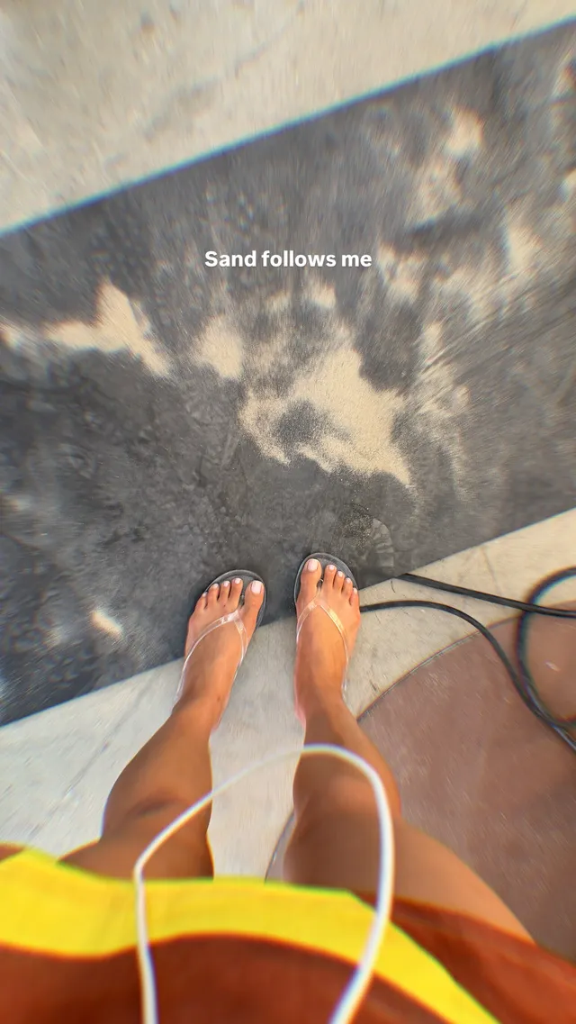 Shay Mitchell a casual view of bare feet beside a sandy path.
