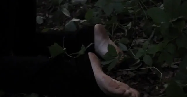 Victoria Pedretti a close-up of bare feet during a dark screen scene.