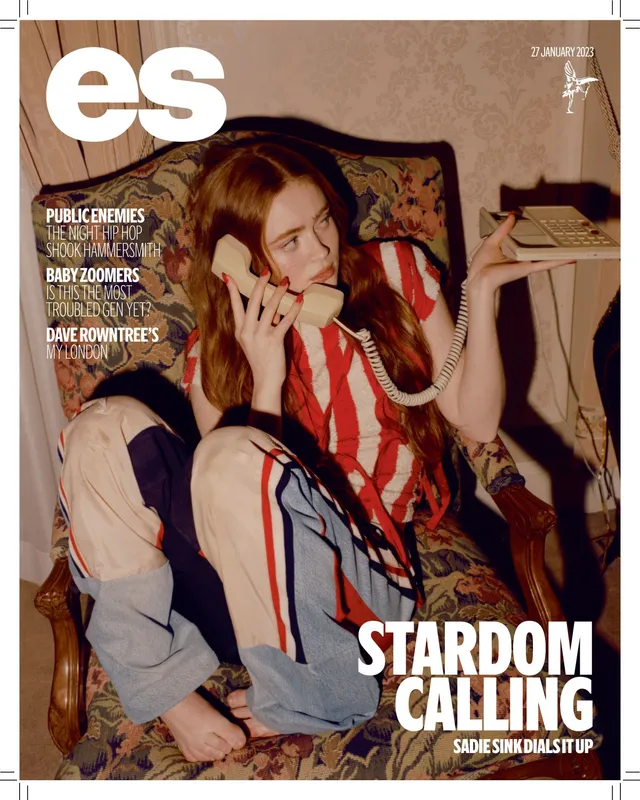 Sadie Sink sitting barefoot in a striped outfit for a magazine cover.