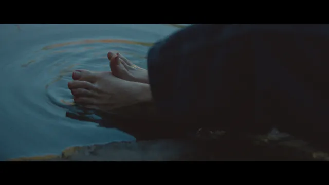 Chloë Grace Moretz with bare soles facing the camera in a screen image.