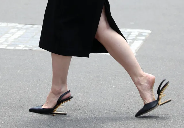 Lily James walking in black slingback heels.