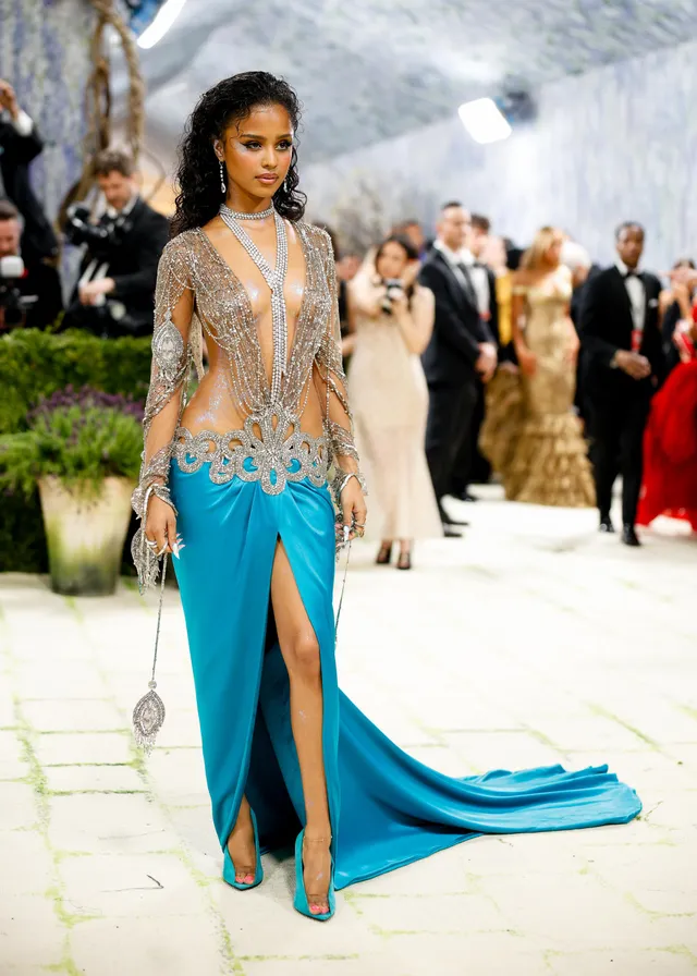 Tyla wearing clear heels beneath a turquoise gown at an evening event.