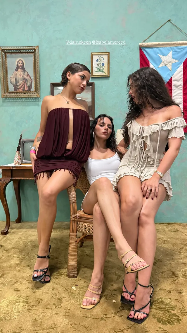 Dafne Keen standing beside friends in a short dark dress and heels.