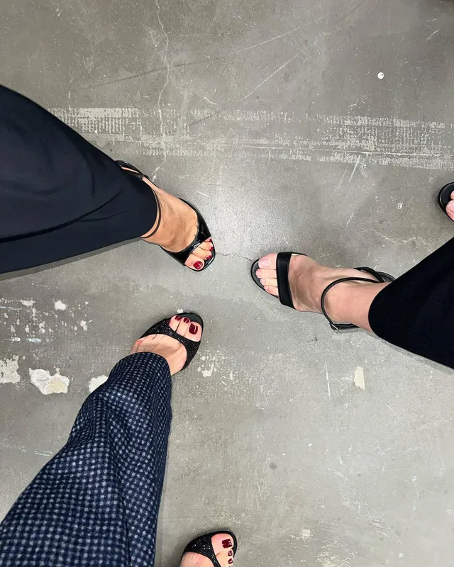 Debby Ryan standing with others in black sandals.