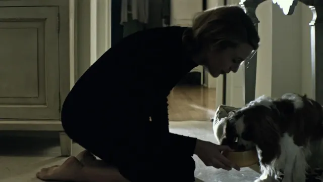 Blake Lively kneeling beside another performer in a screen scene.
