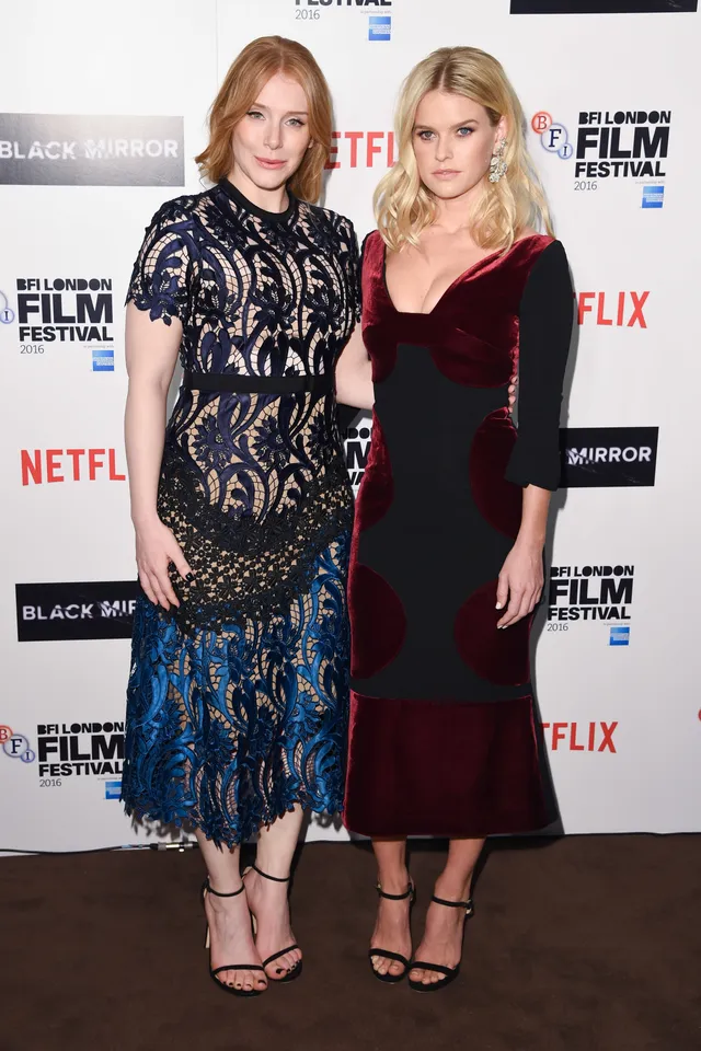 Alice Eve posing with a guest at a film event.