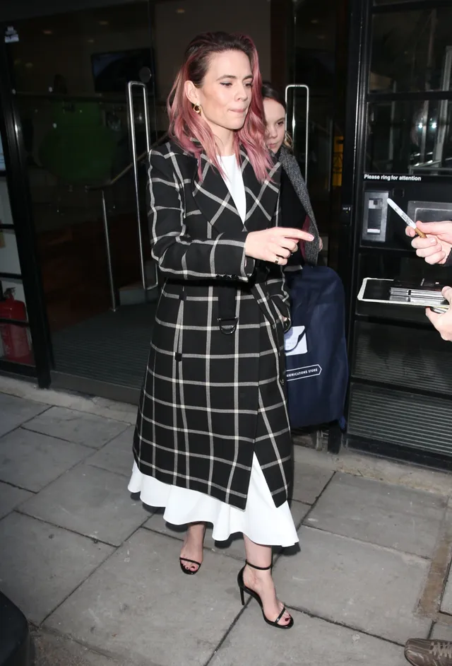Hayley Atwell signing for fans in a checked coat.