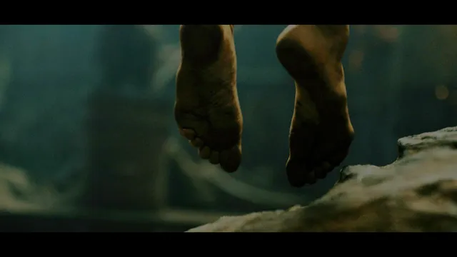 Charlize Theron a screen close detail of bare soles above a ledge.