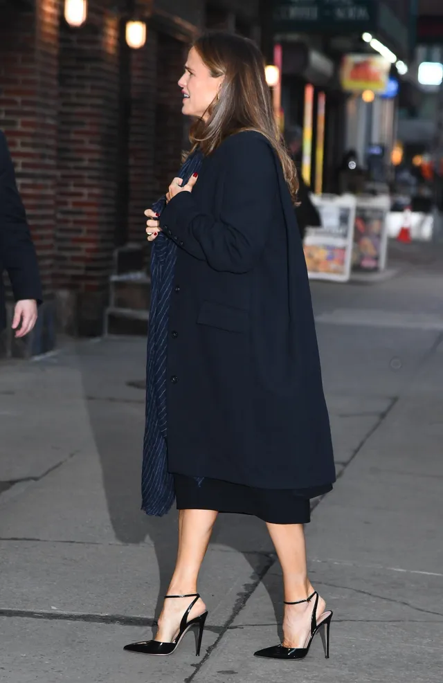 Jennifer Garner walking outdoors at night in a dark dress.