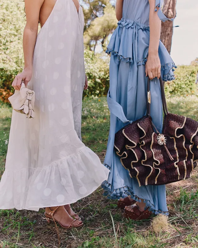 Alycia Debnam-Carey standing beside a companion outdoors in a white dress.
