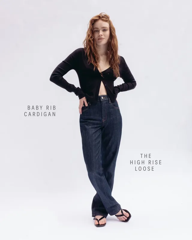 Sadie Sink wearing black flip-flops with loose jeans.