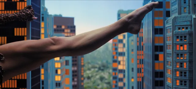 Sydney Sweeney in a cropped action-film still showing a raised bare leg against city buildings.
