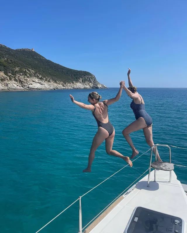 AnnaSophia Robb jumping into the sea with a companion.
