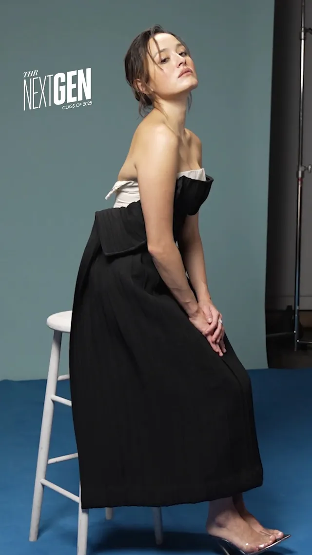 Chase Sui Wonders sitting barefoot on a stool in a black dress.