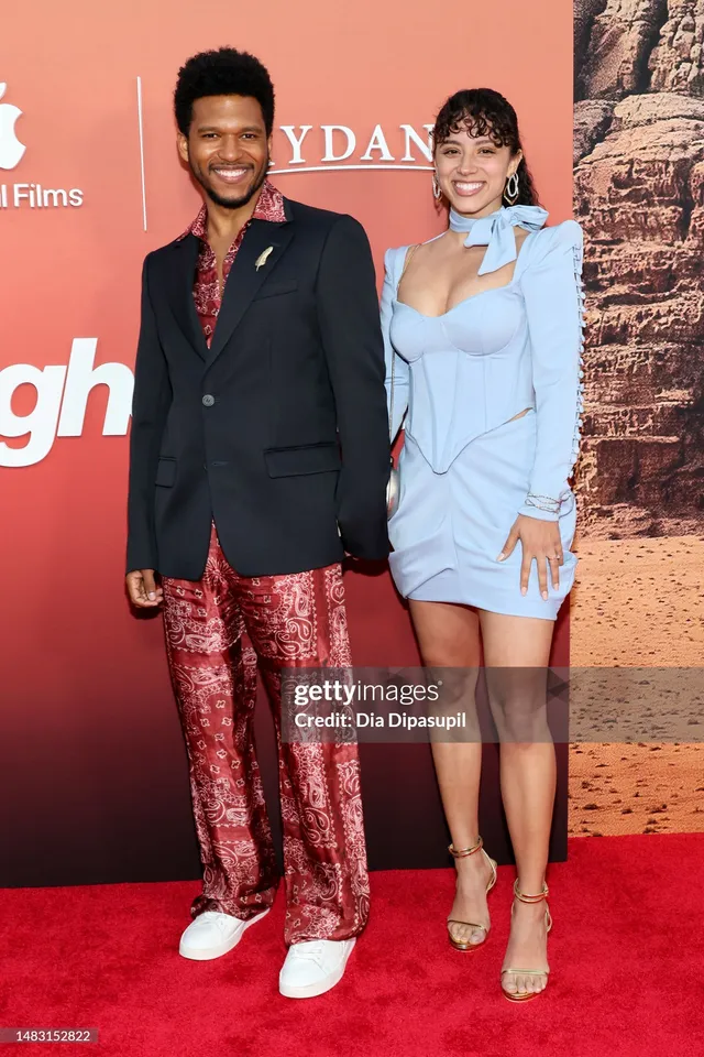 Kiana Madeira wearing a blue mini dress and pale heels on a red carpet.