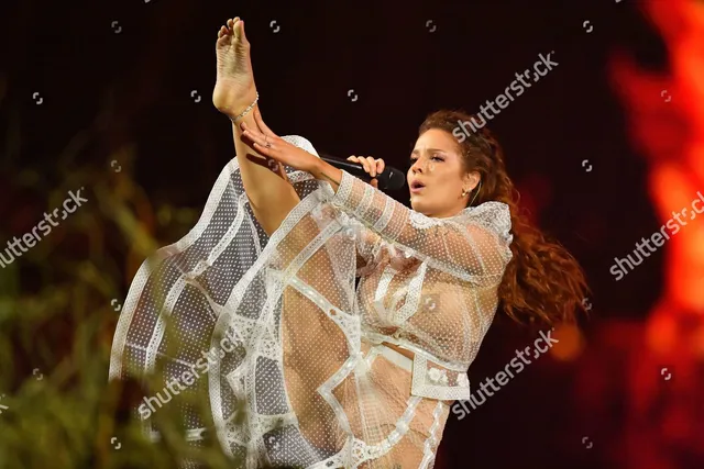 Halsey a stage pose with a raised bare foot.