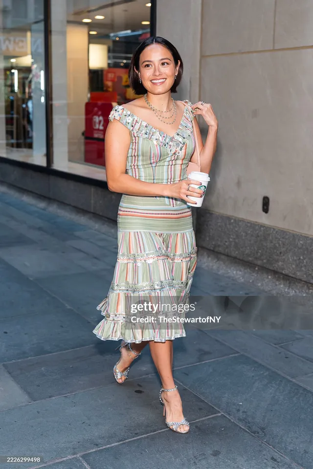 Chase Sui Wonders wearing a striped dress and clear heels outdoors.
