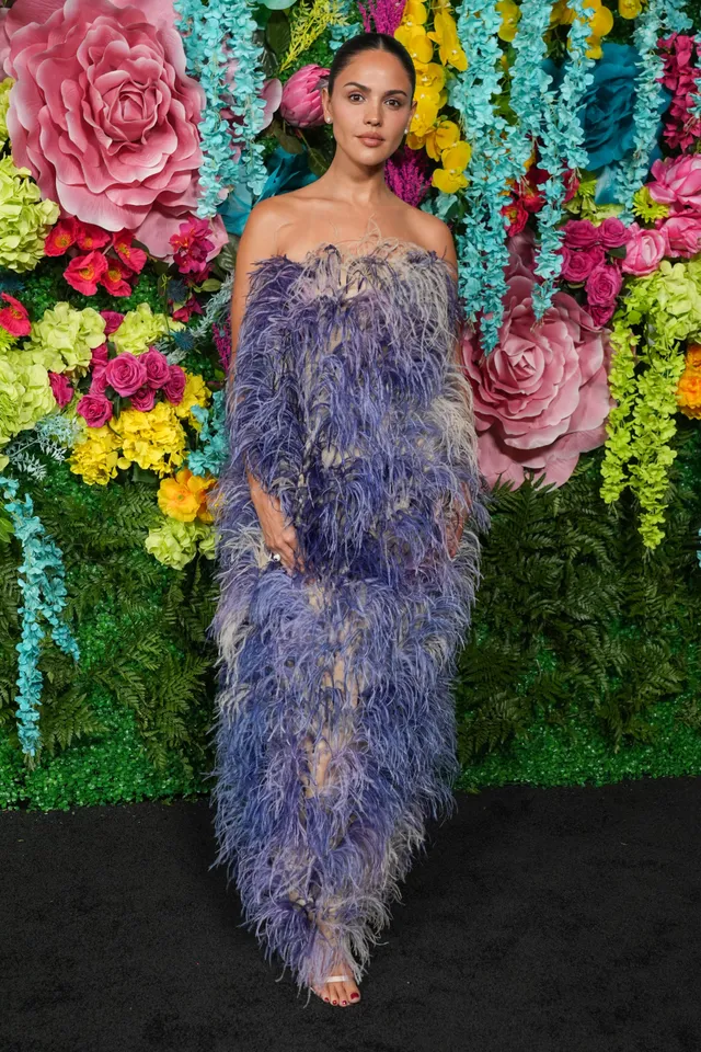 Eiza González posing in a purple textured gown and metallic heels.