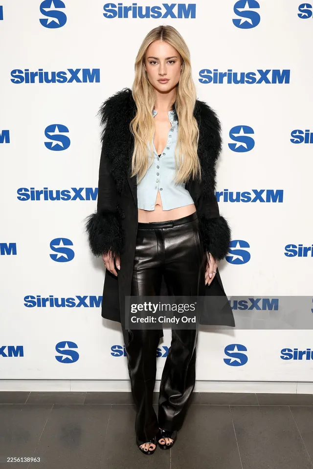 Grace Van Patten wearing black leather trousers and black heels at an event.