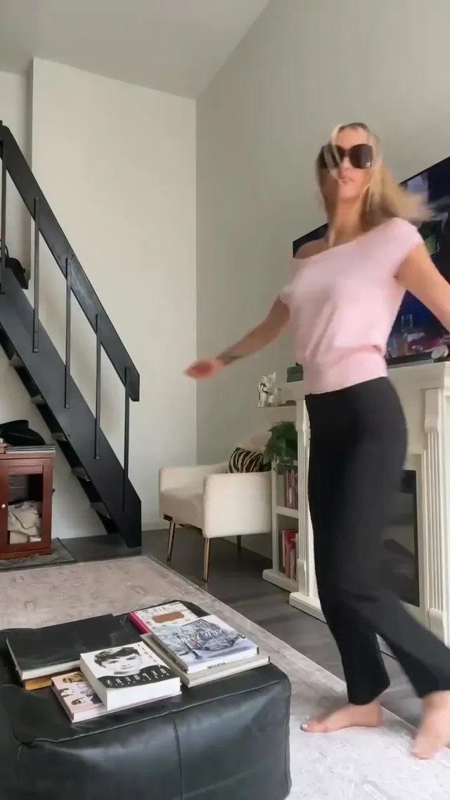Grace VanderWaal standing barefoot indoors in dark trousers.
