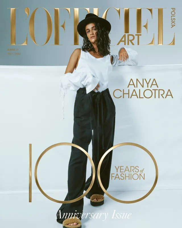 Anya Chalotra posing in trousers and gold platform heels for a magazine cover.