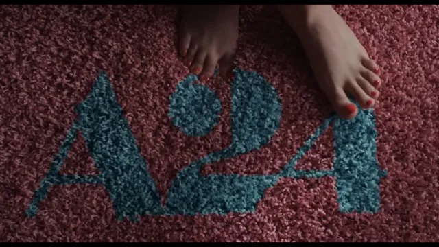 Cailee Spaeny showing her bare feet on a carpet marked with a room number.