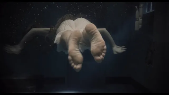 Léa Seydoux floating underwater in a screen scene.
