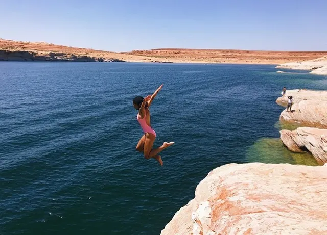 Samantha Logan jumping barefoot from rocks into the sea.