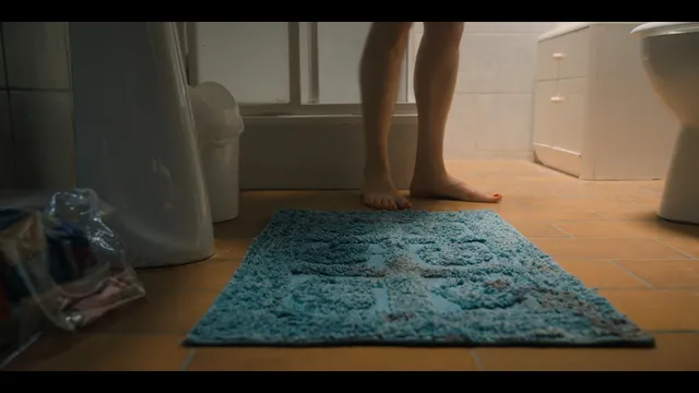 Grace Van Patten shown barefoot in a bathroom scene.
