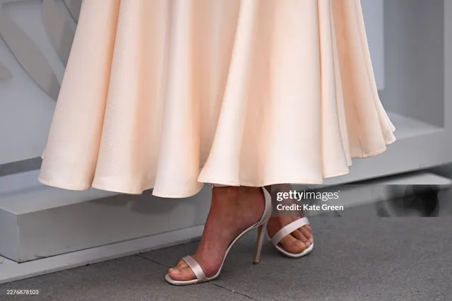 Alicia Vikander wearing pale satin sandals with a cream outfit.