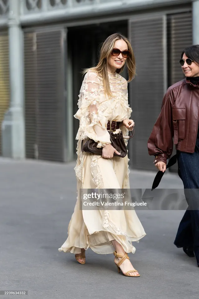 Olivia Wilde walking in a pale flowing dress and platform heels.
