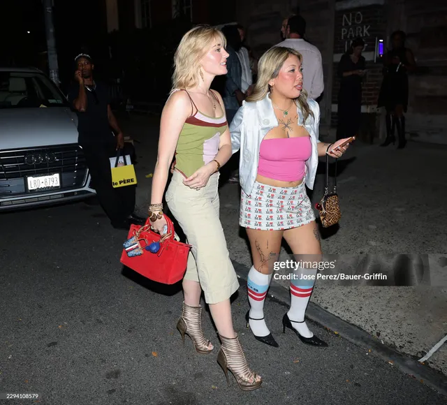 Meg Donnelly walking beside a friend in a colorful top, pale skirt and metallic heels.