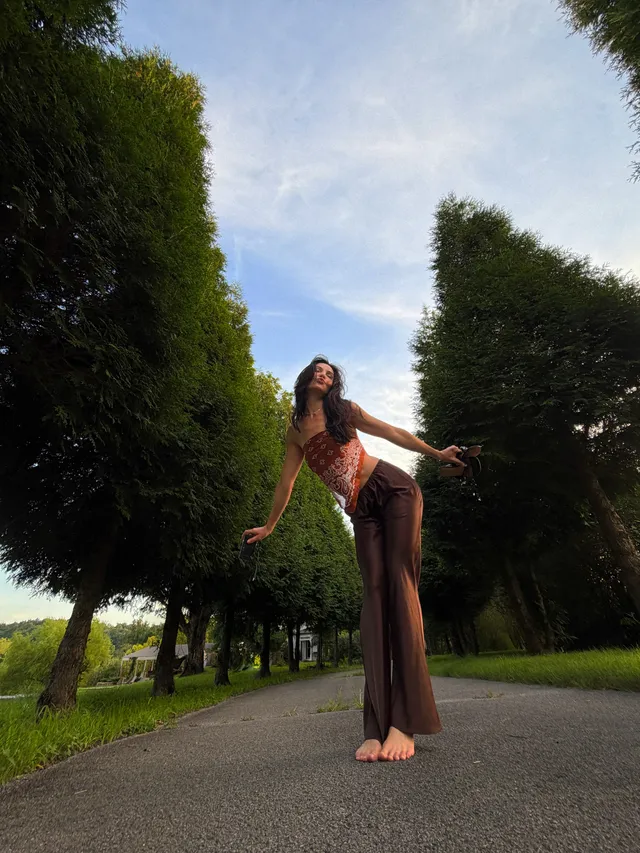 Danielle Campbell posing on a tree-lined path.