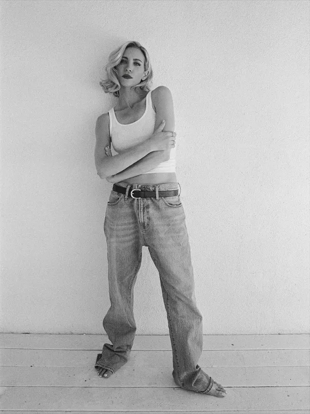 Brittany Snow standing for a black-and-white studio portrait in jeans.