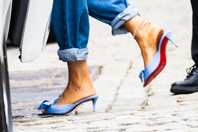 Blake Lively walking outside in jeans and blue heels.