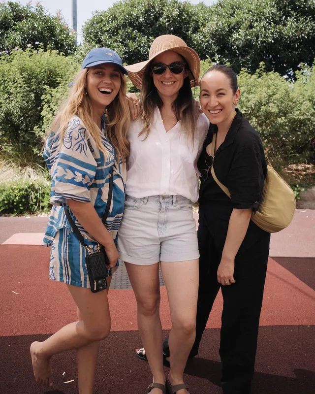 Teresa Palmer posing with companions outdoors in a patterned shirt and shorts.
