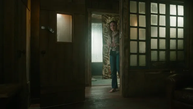 Elizabeth Gillies standing indoors during a screen scene.