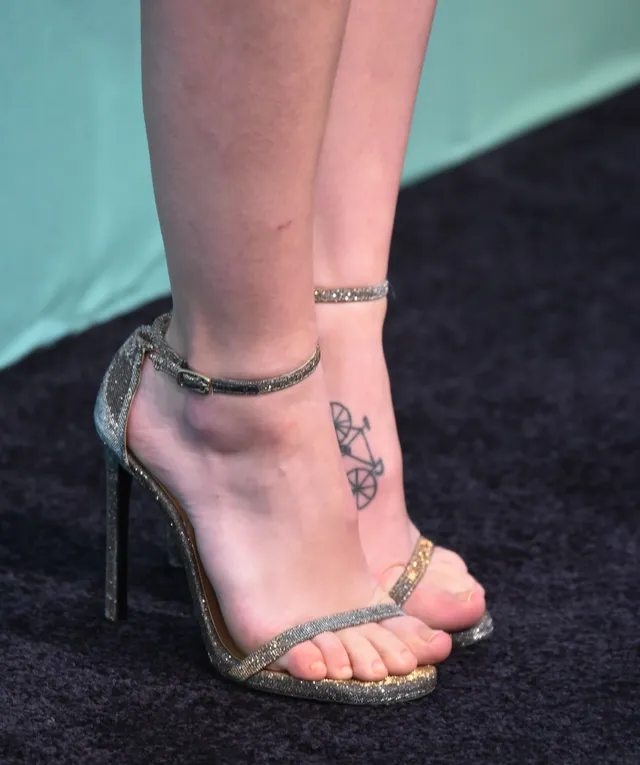 Melissa Benoist wearing metallic ankle strap heels with a tattoo visible.