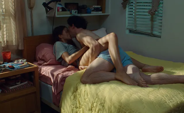 Zendaya: reclining barefoot on a bed with another performer.