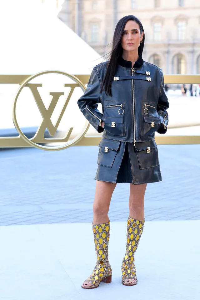 Jennifer Connelly posing at a fashion event in a denim outfit.