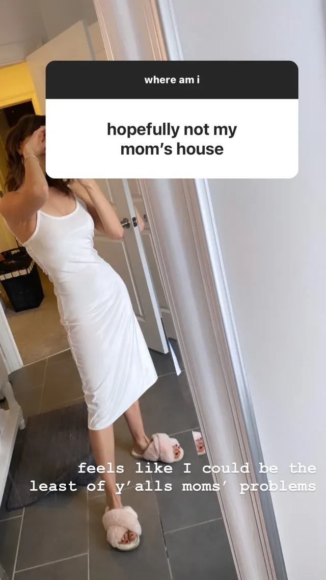 Debby Ryan standing indoors in a white dress and slippers.