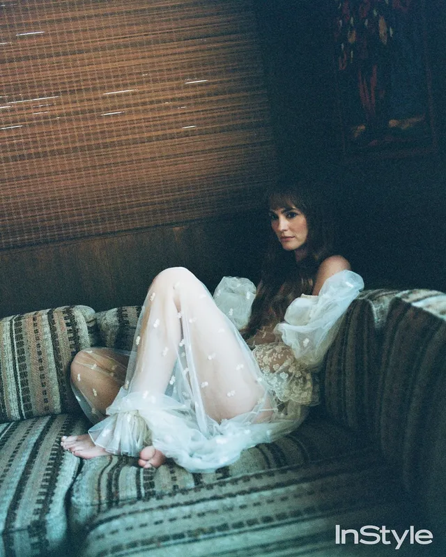 Leighton Meester sitting on a striped sofa for an InStyle portrait.