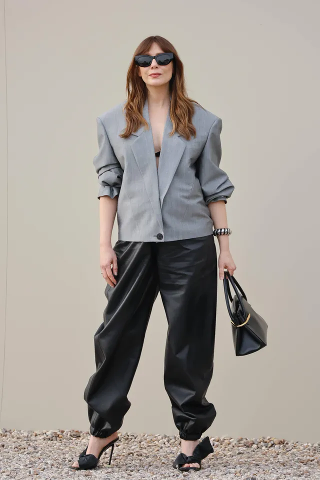 Elizabeth Olsen wearing black heels and loose black trousers.