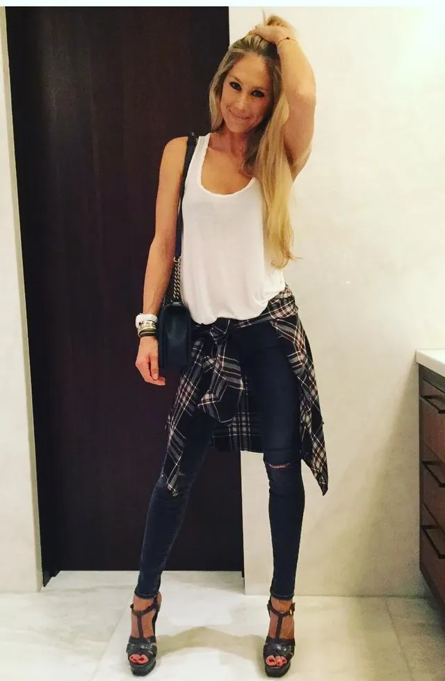 Anna Kournikova wearing dark heeled sandals with fitted trousers and a white top.