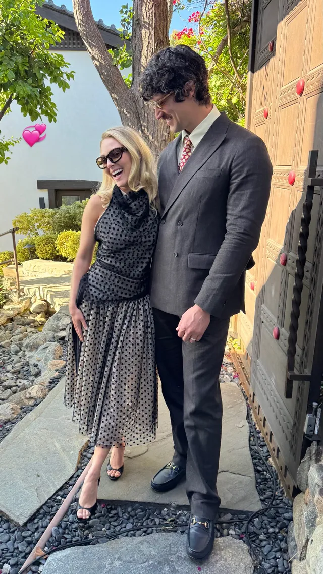 AnnaSophia Robb standing beside a companion in a patterned dress.