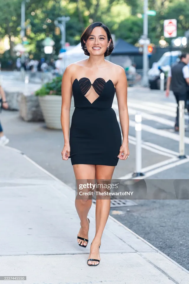 Chase Sui Wonders walking outdoors in a black dress and heels.