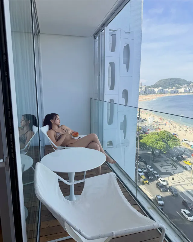 Camila Mendes relaxing on a balcony overlooking the beach.